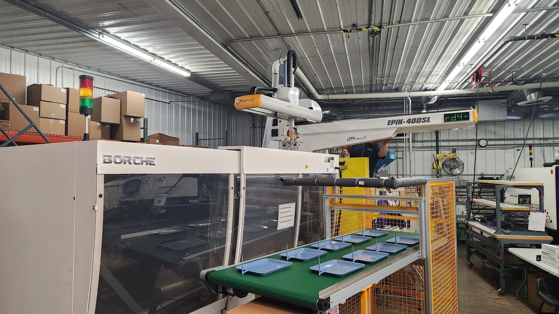 Injection molding machine with a robotic part-removal arm